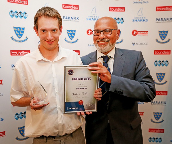 Lewis Pope is presented with his Young Volunteer Award by Sussex Cricket Disability Cricket Manager Aroop Tanna