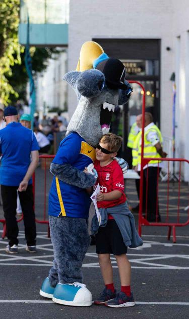 sandy the shark and a sussex fan embrace at a t20 match