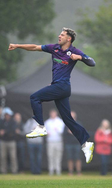 Brad Currie celebrates taking a wicket for Scotland