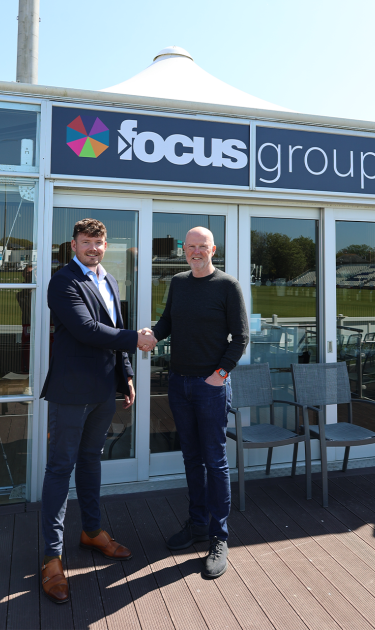 Wesley McGovern and Mark West shake hands in front of the new Focus Group Executive Lounge.