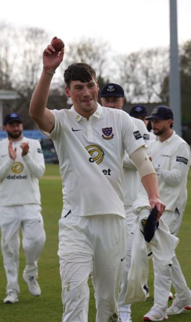 Crocombe raises the ball, acknowledging the applause for his five-fer.