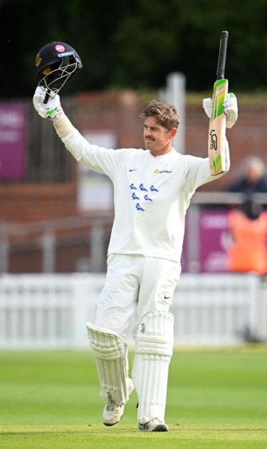 Daniel Hughes raises his bat in celebration of his century against Somerset.