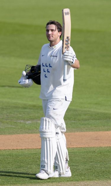 James Coles raises his bat to celebrate his century against Glamorgan