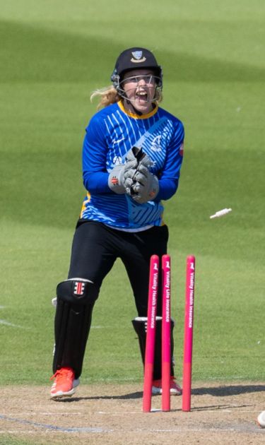 Mollie Adams celebrating a wicket from behind the stumps.