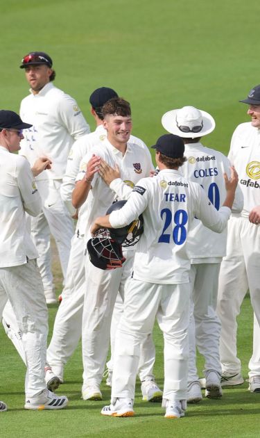 Henry Crocombe celebrates his five-fer with his teammates.