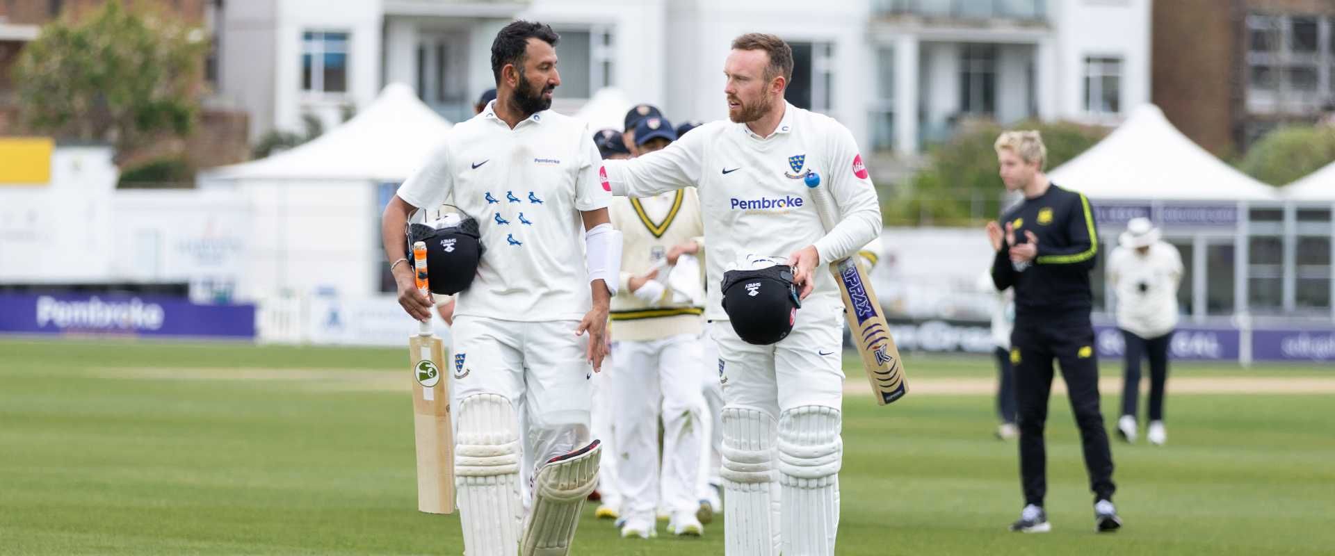 Cheteshwar Pujara and Danny Lamb walk off the pitch at The 1st Central County Ground