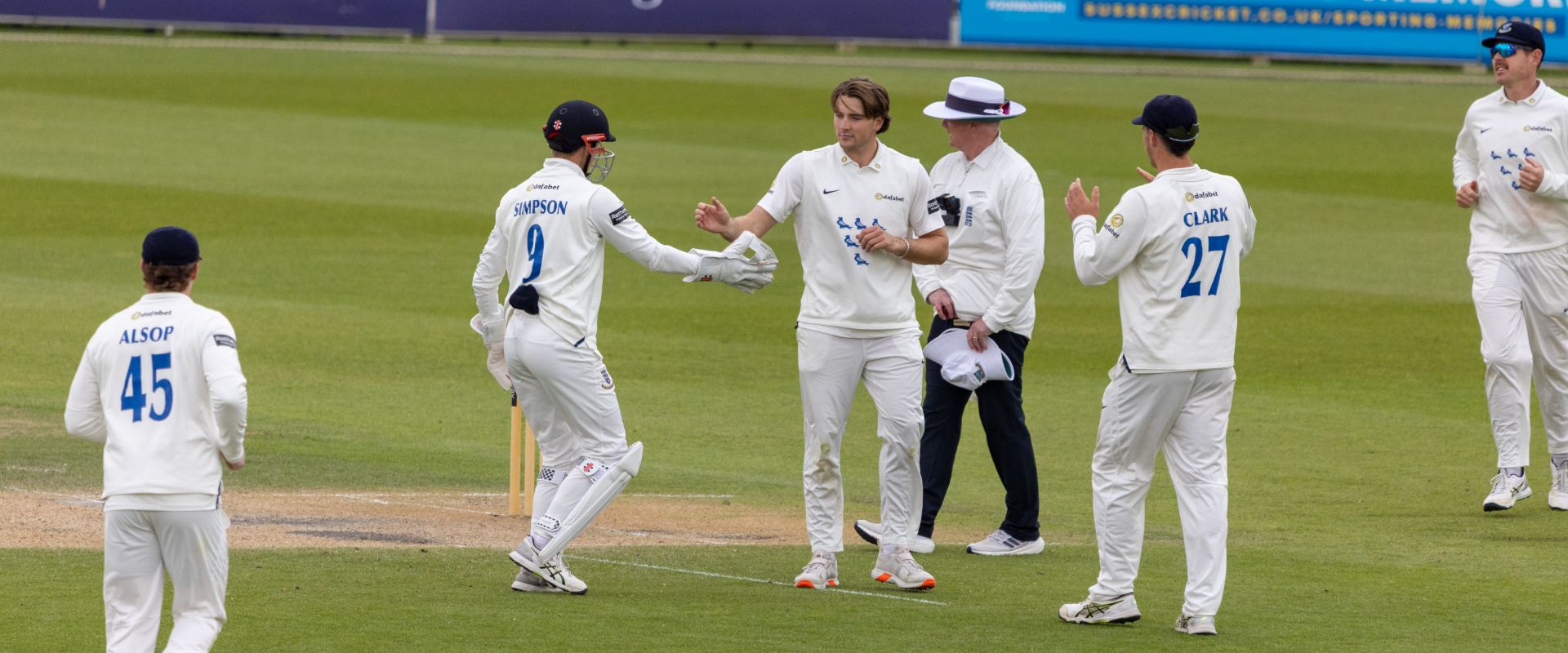 Sussex players celebrate after James Coles picks up a wicket on Day Three