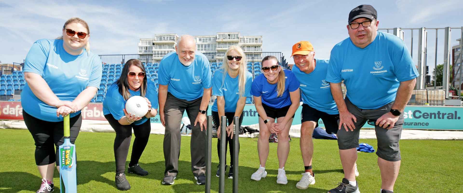volunteers pose with cricket stumps at discoverability day