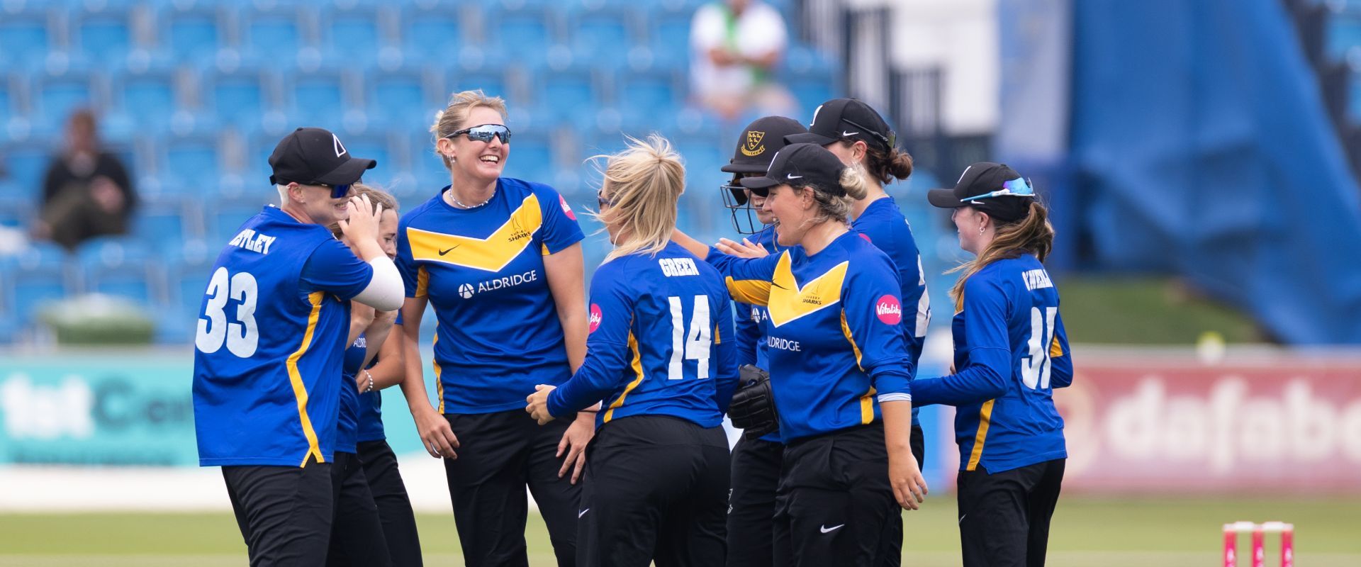 Sussex Sharks Women celebrate a wicket together.