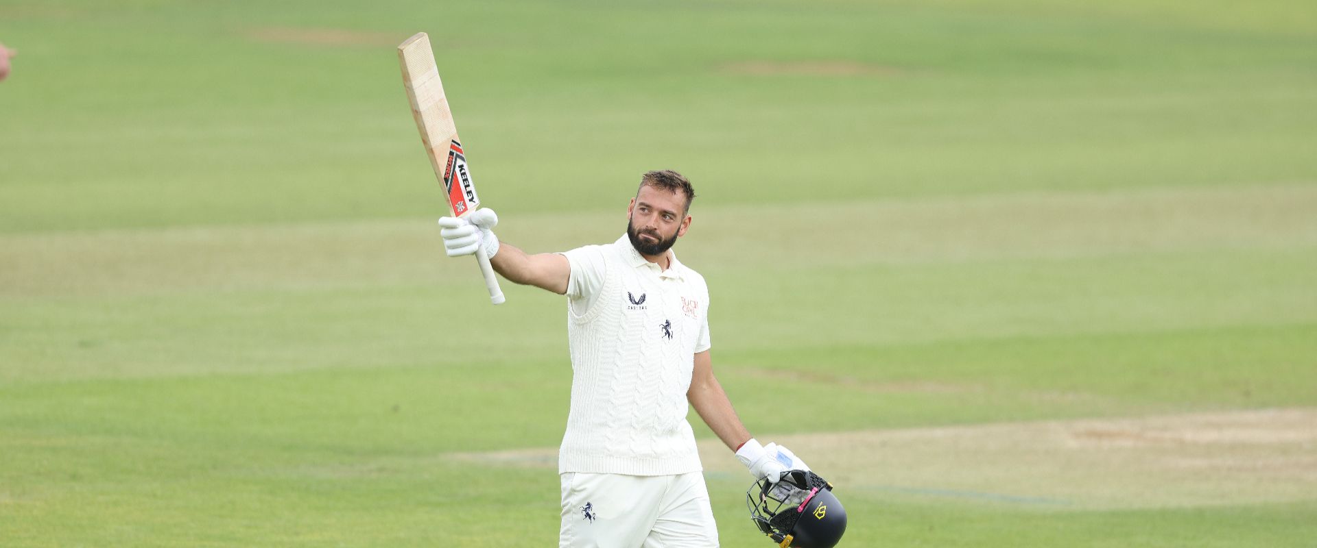 Jack Leaning raises the bat after scoring a century