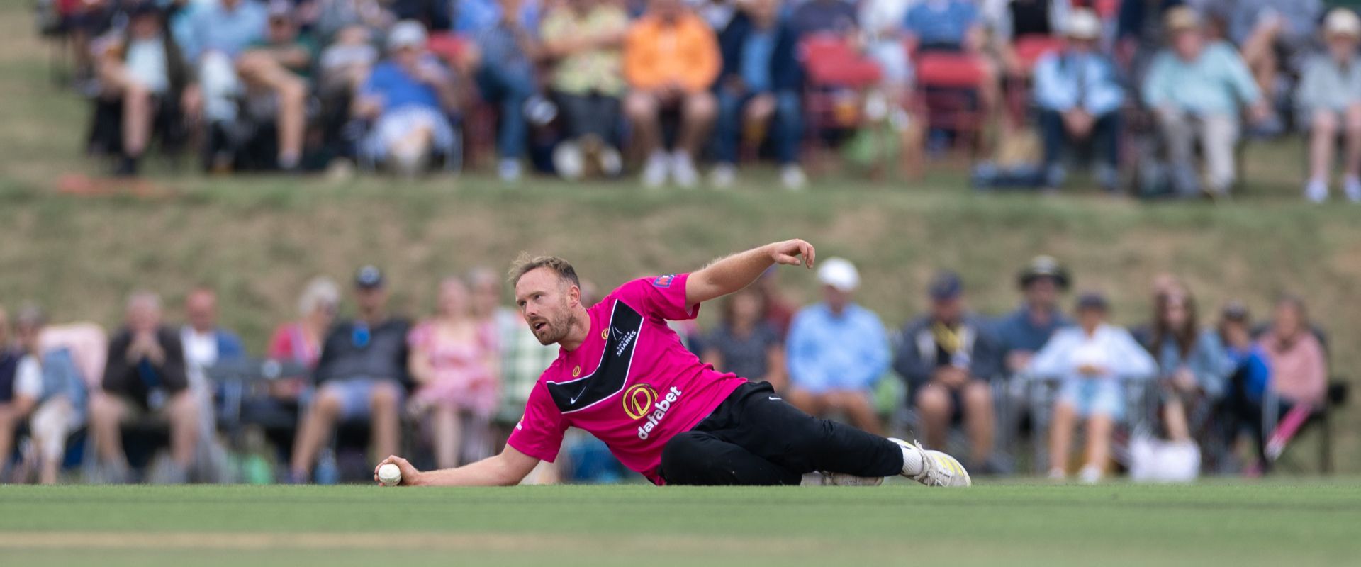 Danny Lamb fielding in front of a packed crowd at Arundel