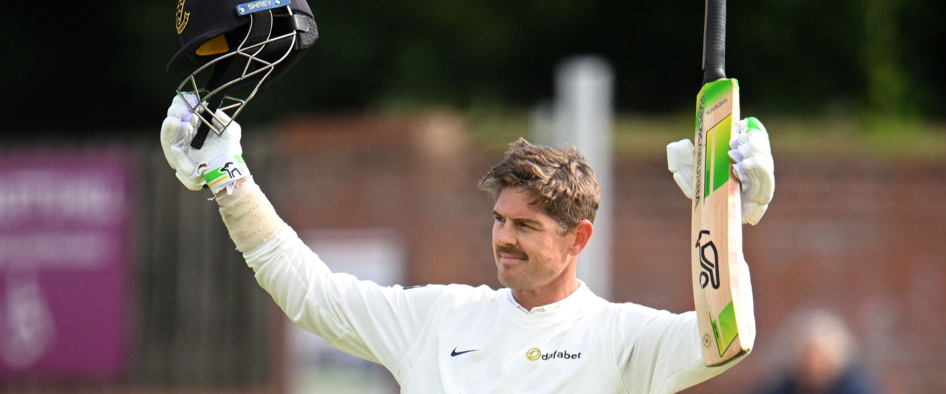 Daniel Hughes raises his bat in celebration of his century against Somerset.