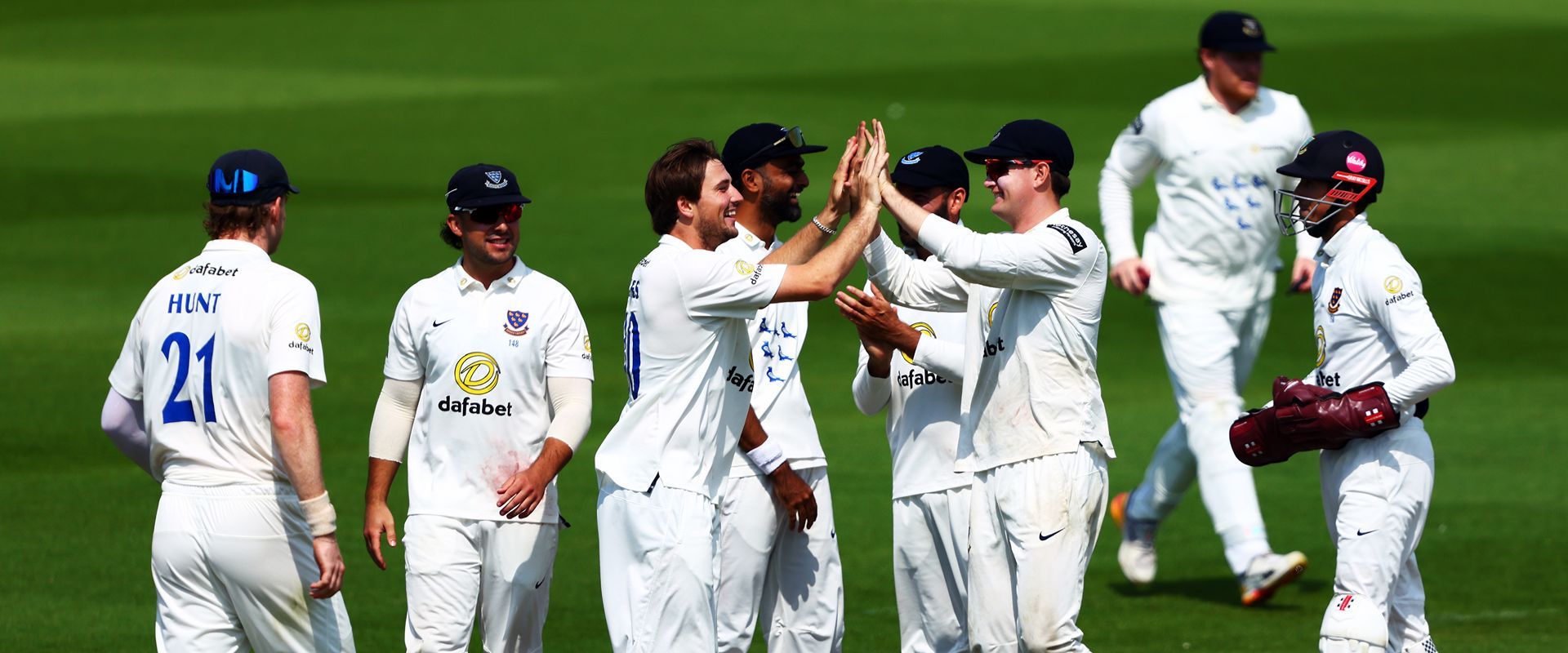 Sussex squad celebrating a wicket.