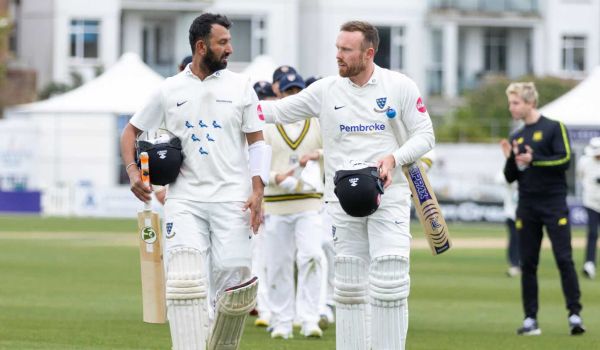 Cheteshwar Pujara and Danny Lamb walk off the pitch at The 1st Central County Ground