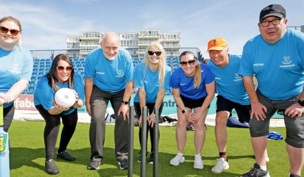 volunteers pose with cricket stumps at discoverability day