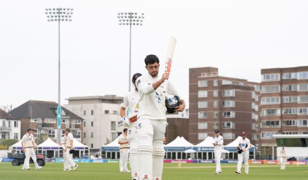 Tom Haines raises his bat after scoring a century against Somerset 