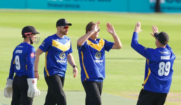 Sussex players celebrate a wicket with James Coles.