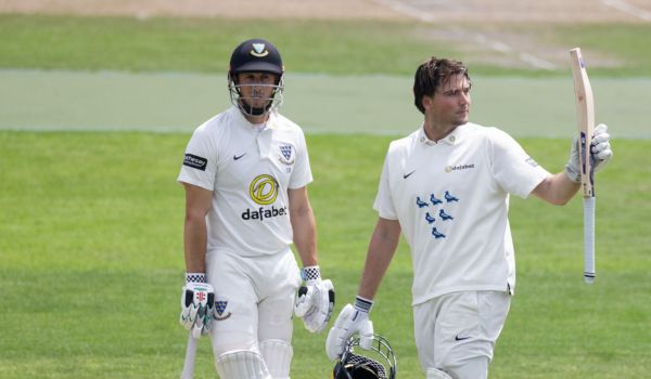 James Coles raises his bat to celebrate his century against Warwickshire.