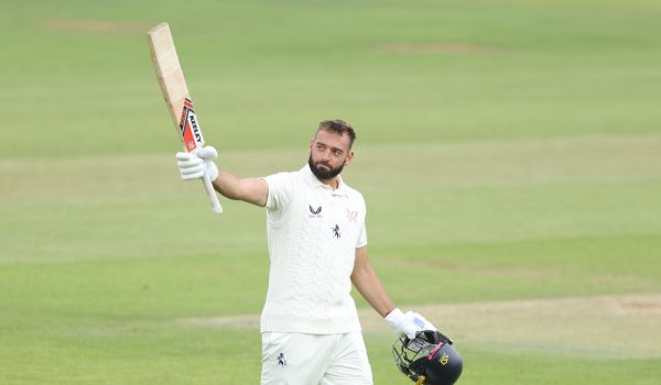 Jack Leaning raises the bat after scoring a century