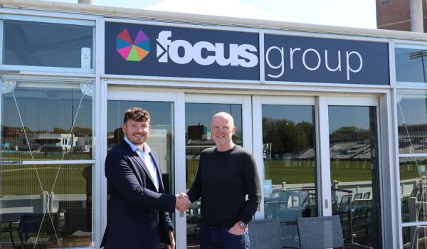 Wesley McGovern and Mark West shake hands in front of the new Focus Group Executive Lounge.