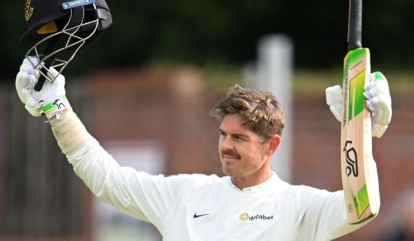 Daniel Hughes raises his bat in celebration of his century against Somerset.